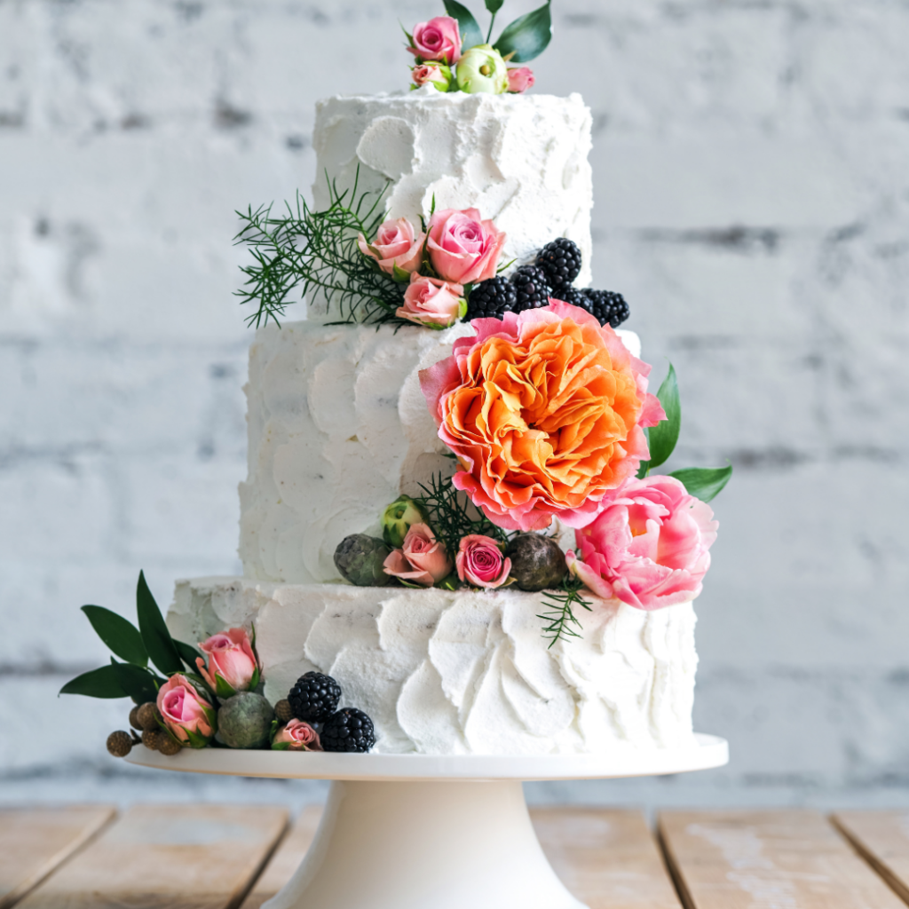 white wedding cake with brush strokes and colourful flowers