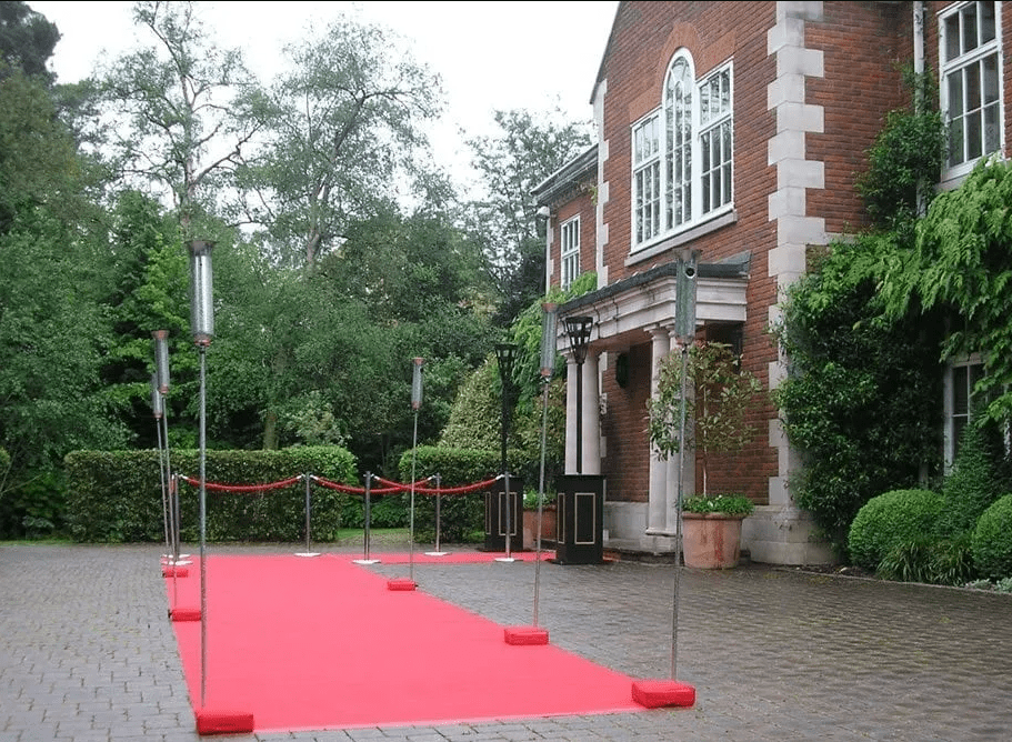 Party lights hiring red carpet out at an event, outside a grand house