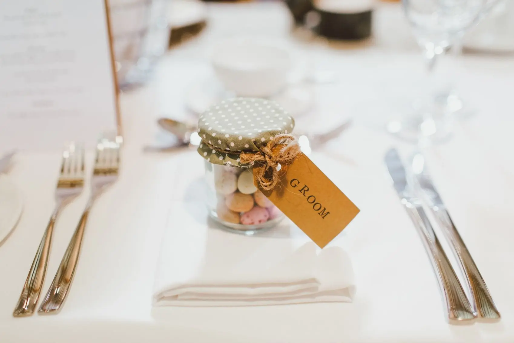 Close up of a Grooms wedding favour- a jar filled with sweets. 