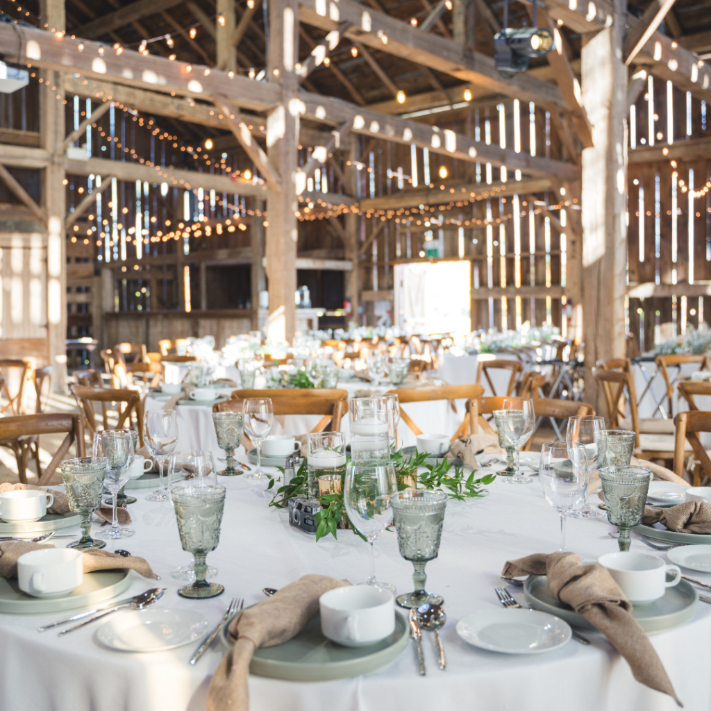 indoor event light for a wedding inside a barn with festoon lights in the ceiling