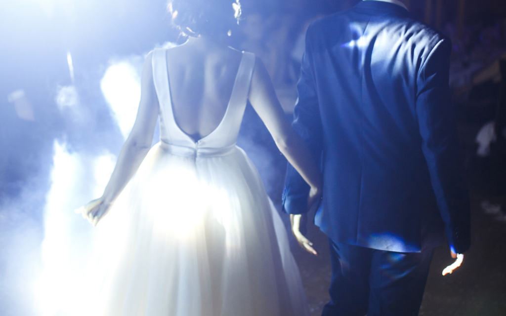 spotlight shining on wedding couple walking onto dance floor