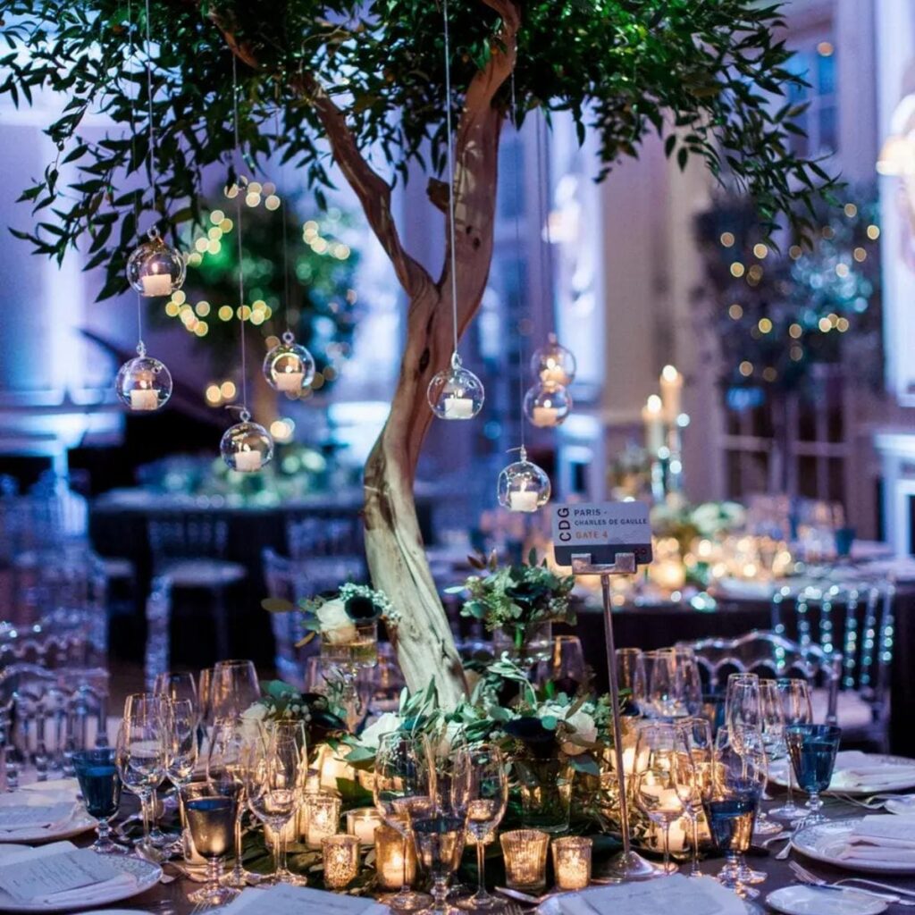 Wedding reception table, with a tree centerpiece dressed in fairy lights and candles.  