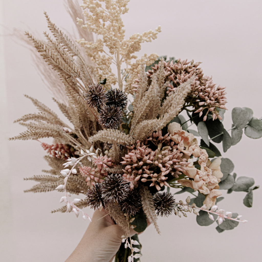 rustic dried wedding flowers being held by a woman