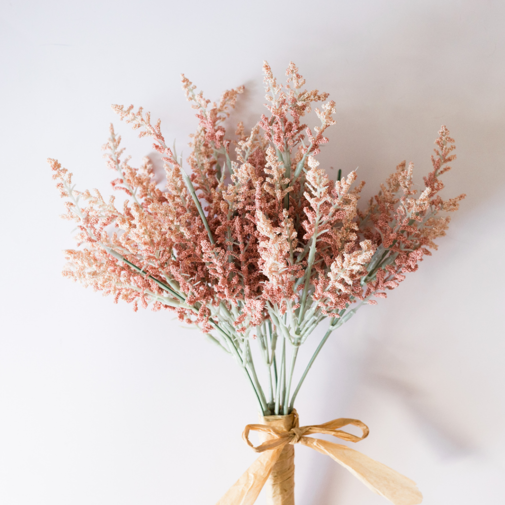 pink minimalist flower bouquet being held against the wall
