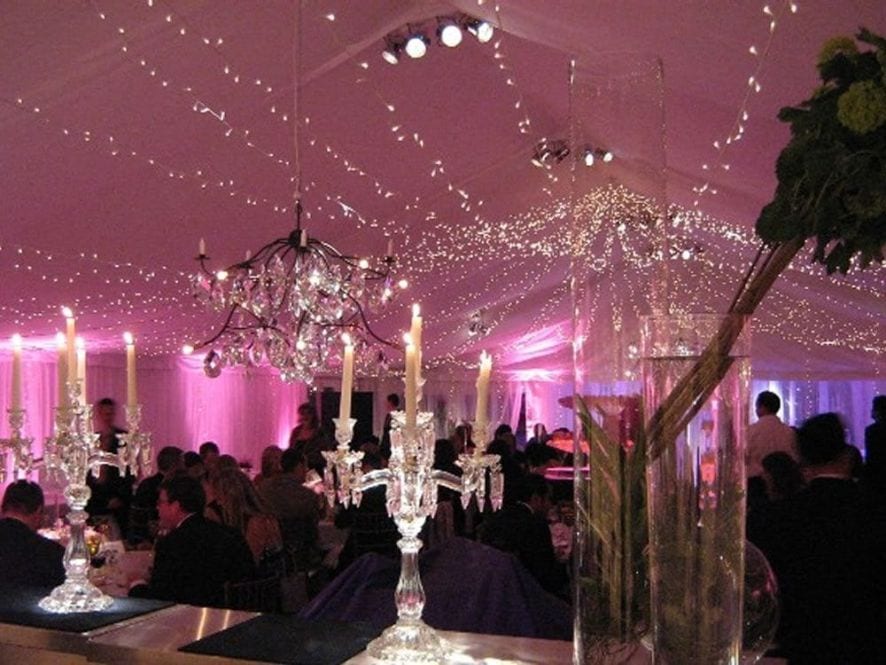 Wedding venue lit up with pink lights and draping fairy lights