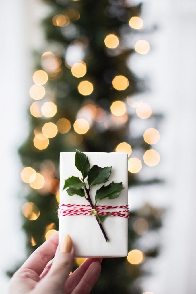 Woman holding a bar os soap with holly leaves tied to it