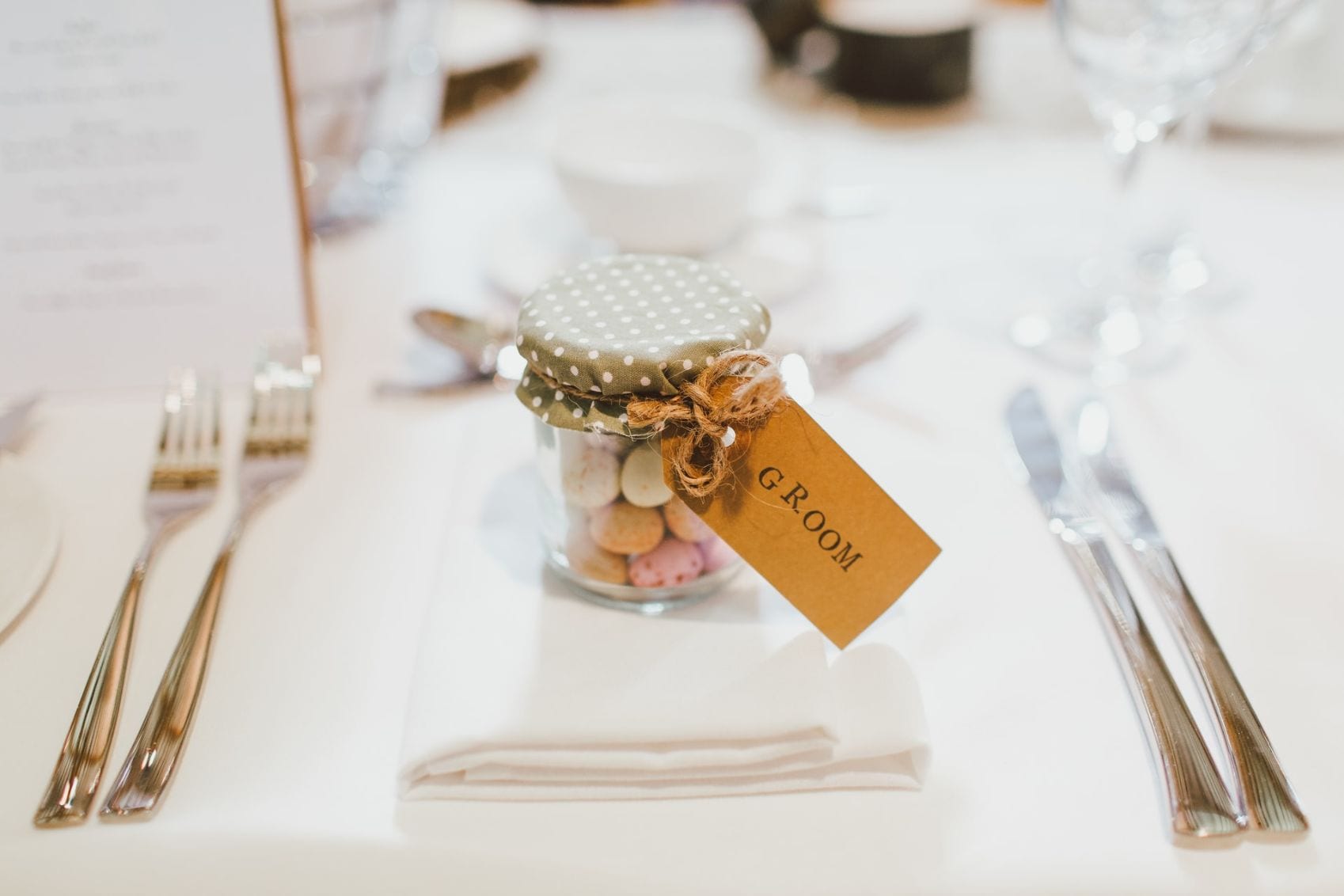 Close up of a Grooms wedding favour- a jar filled with sweets. 
