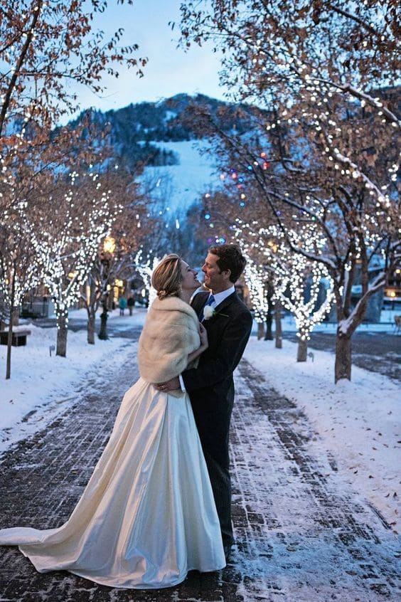 Bride and Groom staring into each others eyes under the outdoor trees wrapped in fairy lights. 