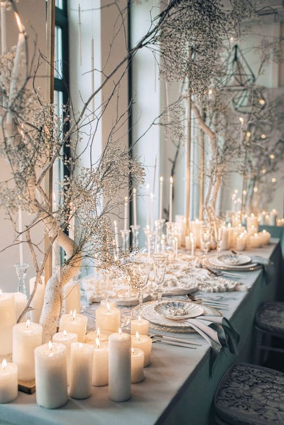 Winter wedding candle lighting ideas, table dressed in white with candles and fairy lights. 